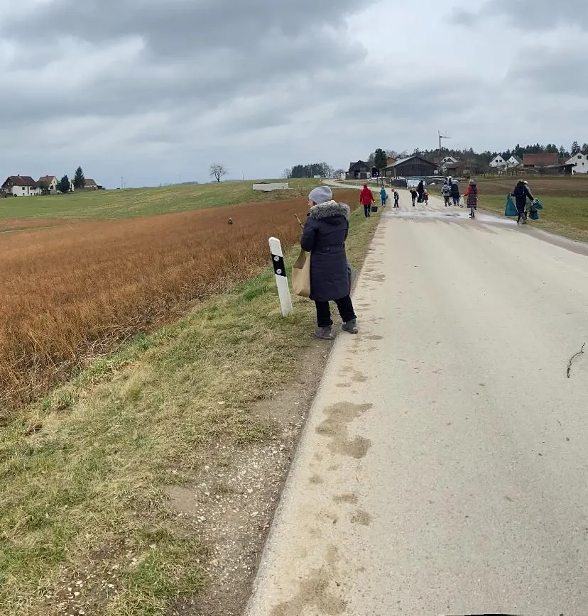 Helferinnen und Helfer sammeln Müll entlang einer Landstraße